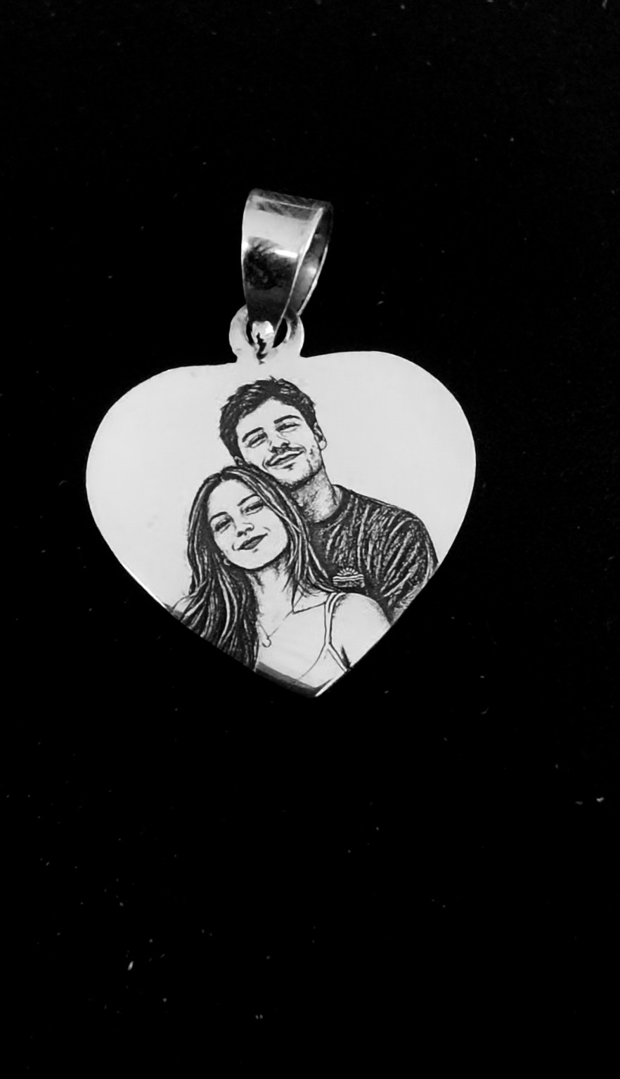 Colgante de corazón con una pareja fotograbada sobre fondo negro